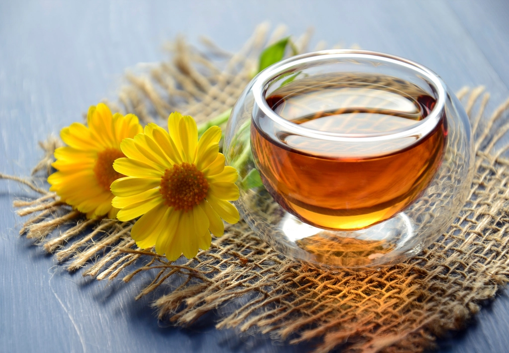 Cup of herbal tea with calendula flowers